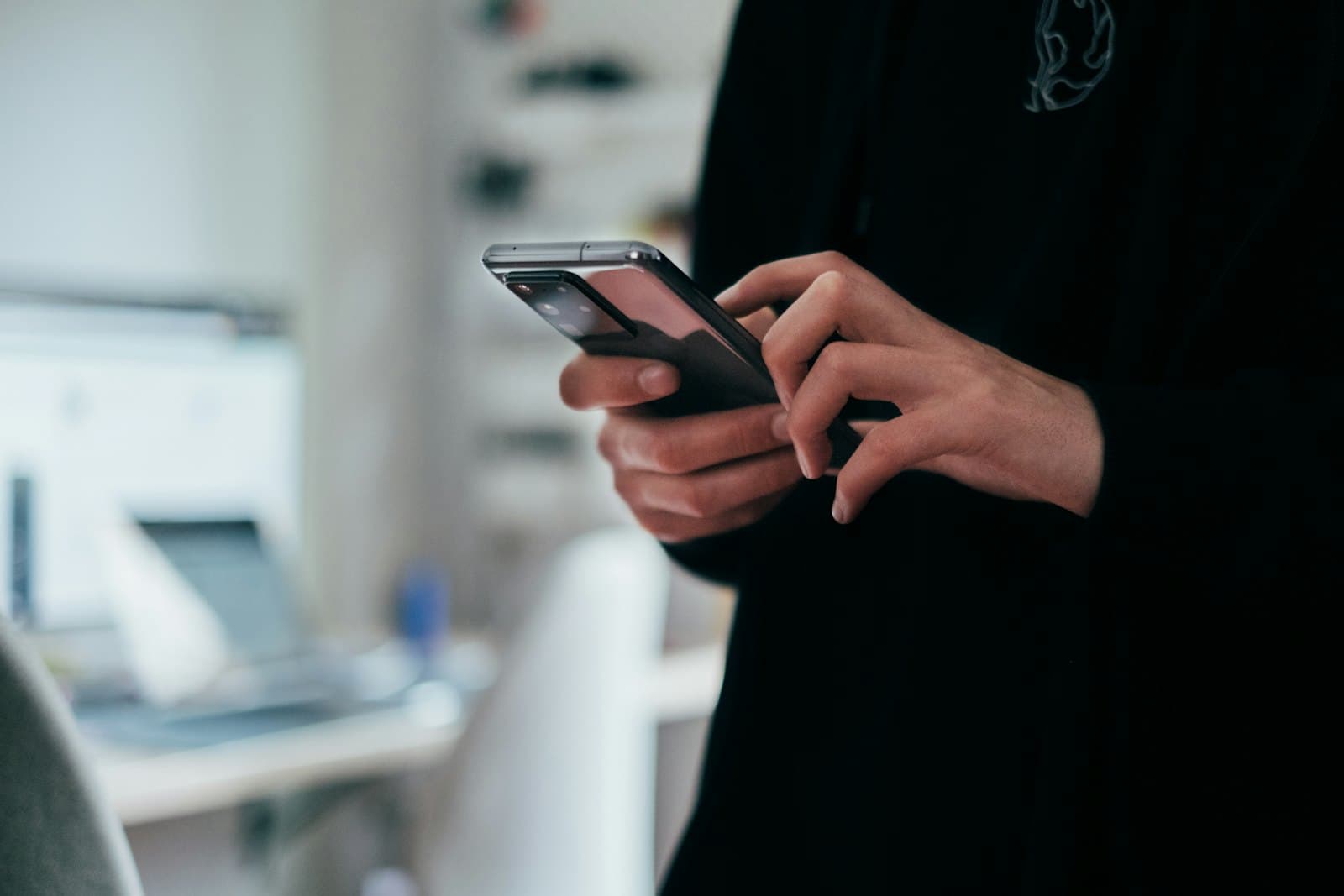 A person holding a smartphone, recording a voice message